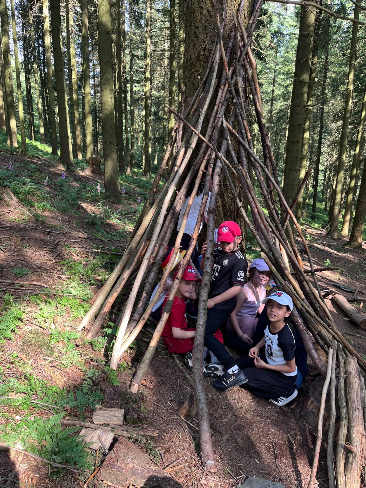 Kinder sitzen in einem Unterschlupf im Wald