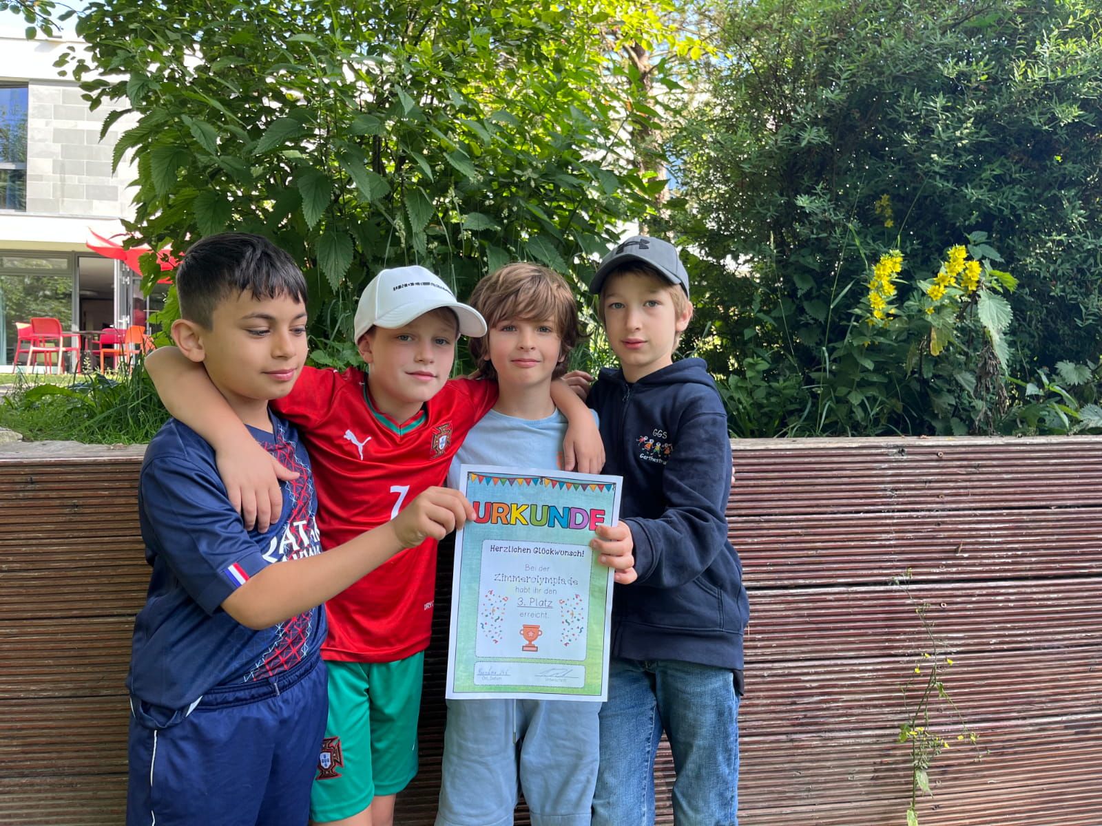 Vier Kinder zeigen ihre Urkunde