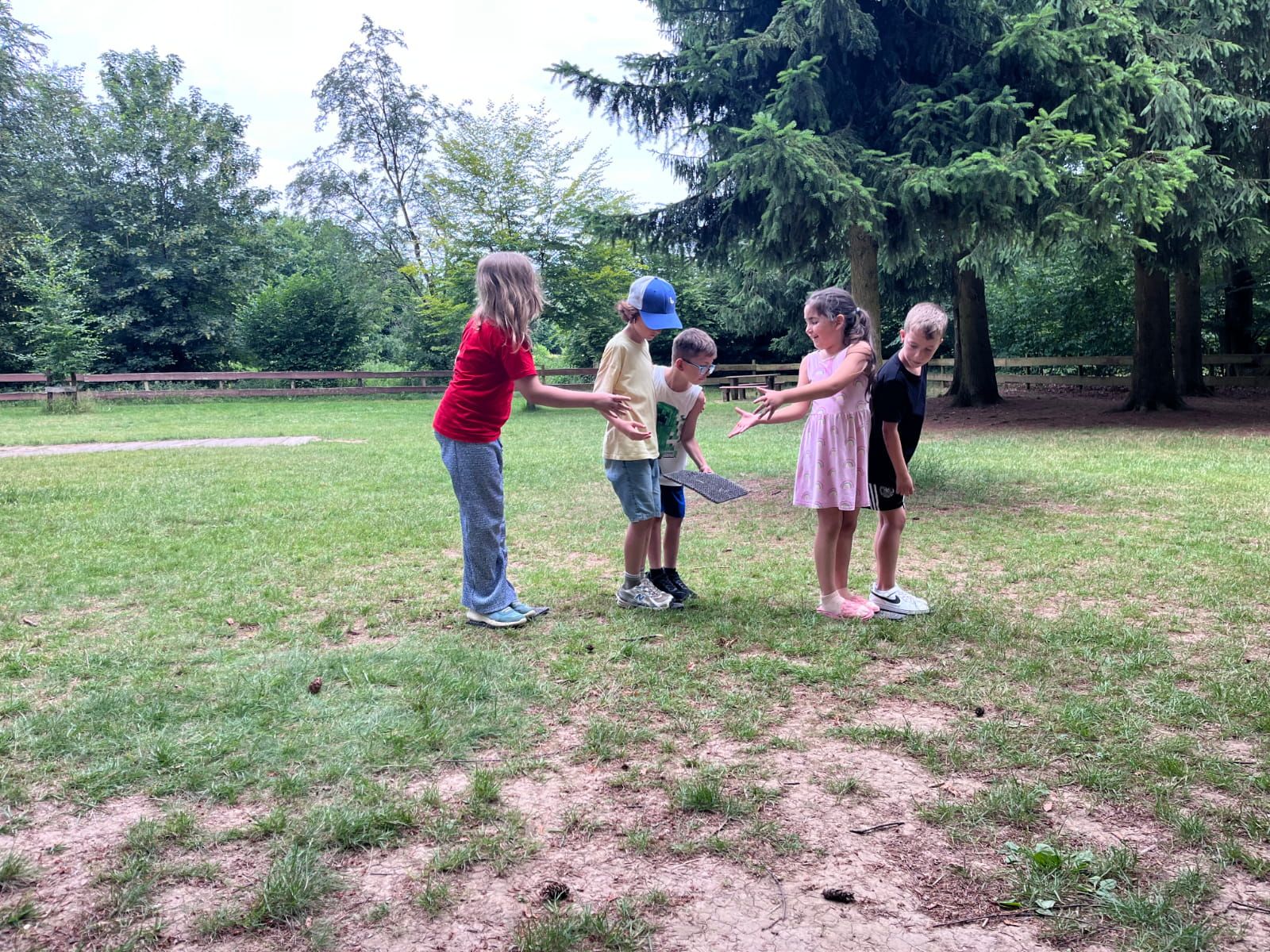 Fünf Kinder spielen auf einer Wiese