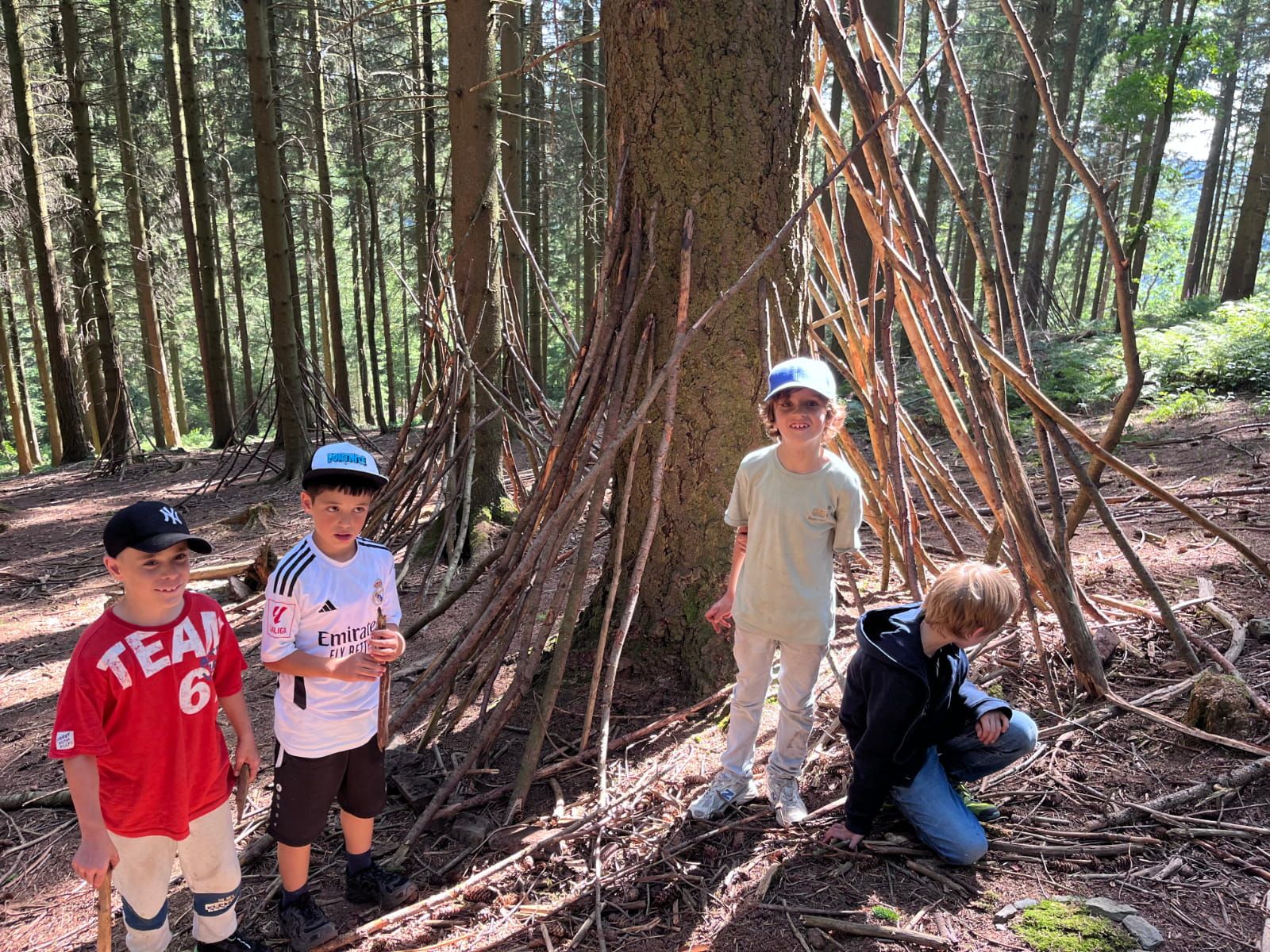 Kinder vor einem Unterschlupf im Wald