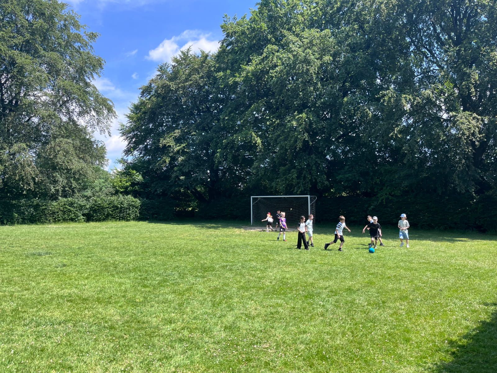 Kinder spielen Fußball auf einer Wiese