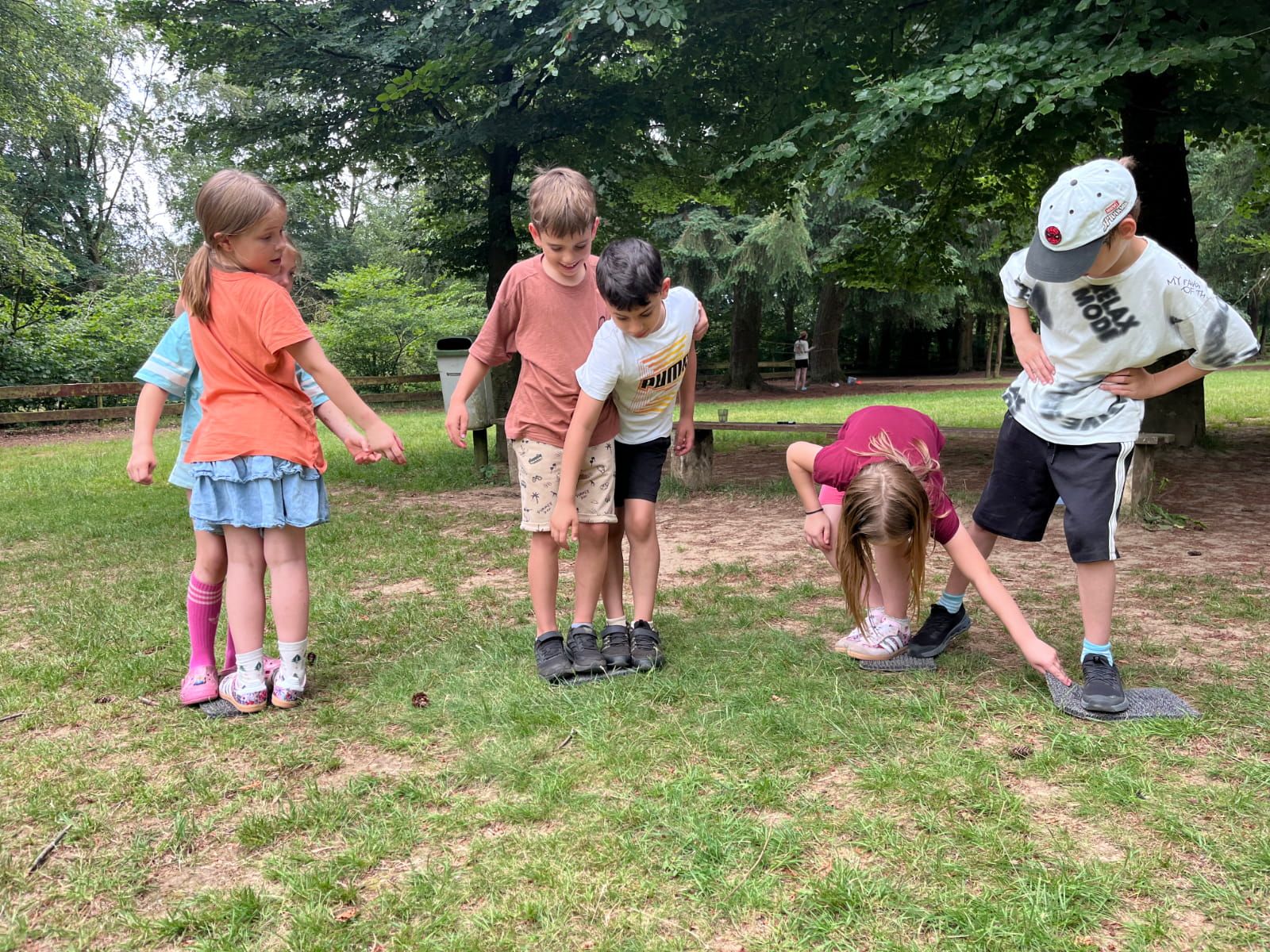 Sechs Kinder spielen auf einer Wiese