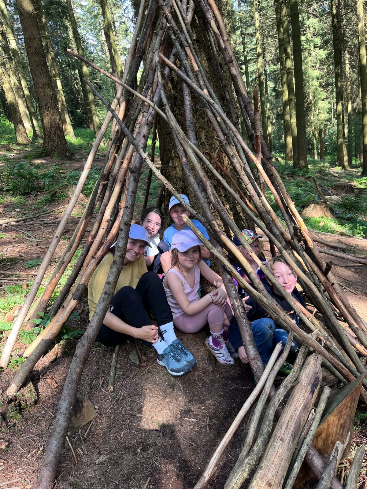 Kinder sitzen in einem Unterschlupf im Wald