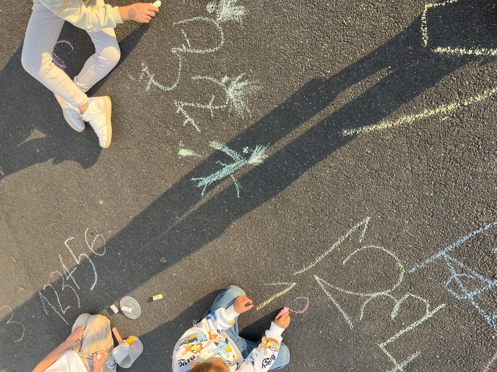 Kinder schreiben Zahlen auf dem Schulhof