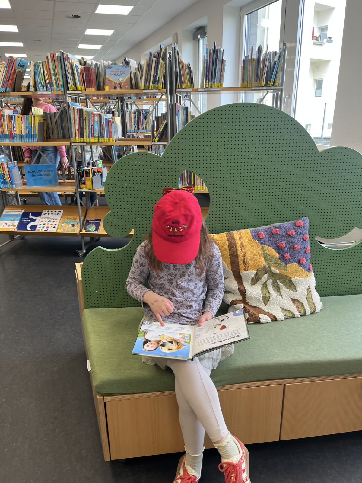 ein Kind liest ein Buch auf einer Bank