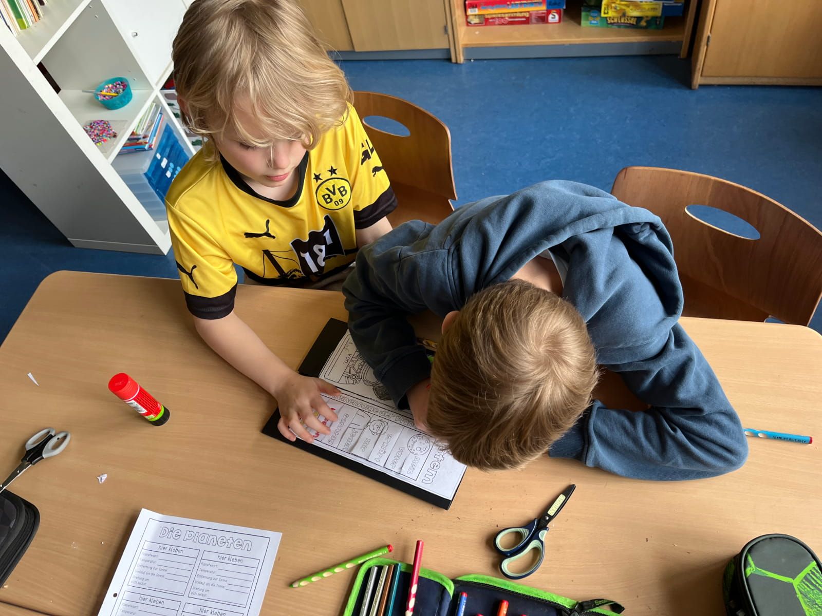zwei Kinder arbeiten an einem Arbeitsblatt