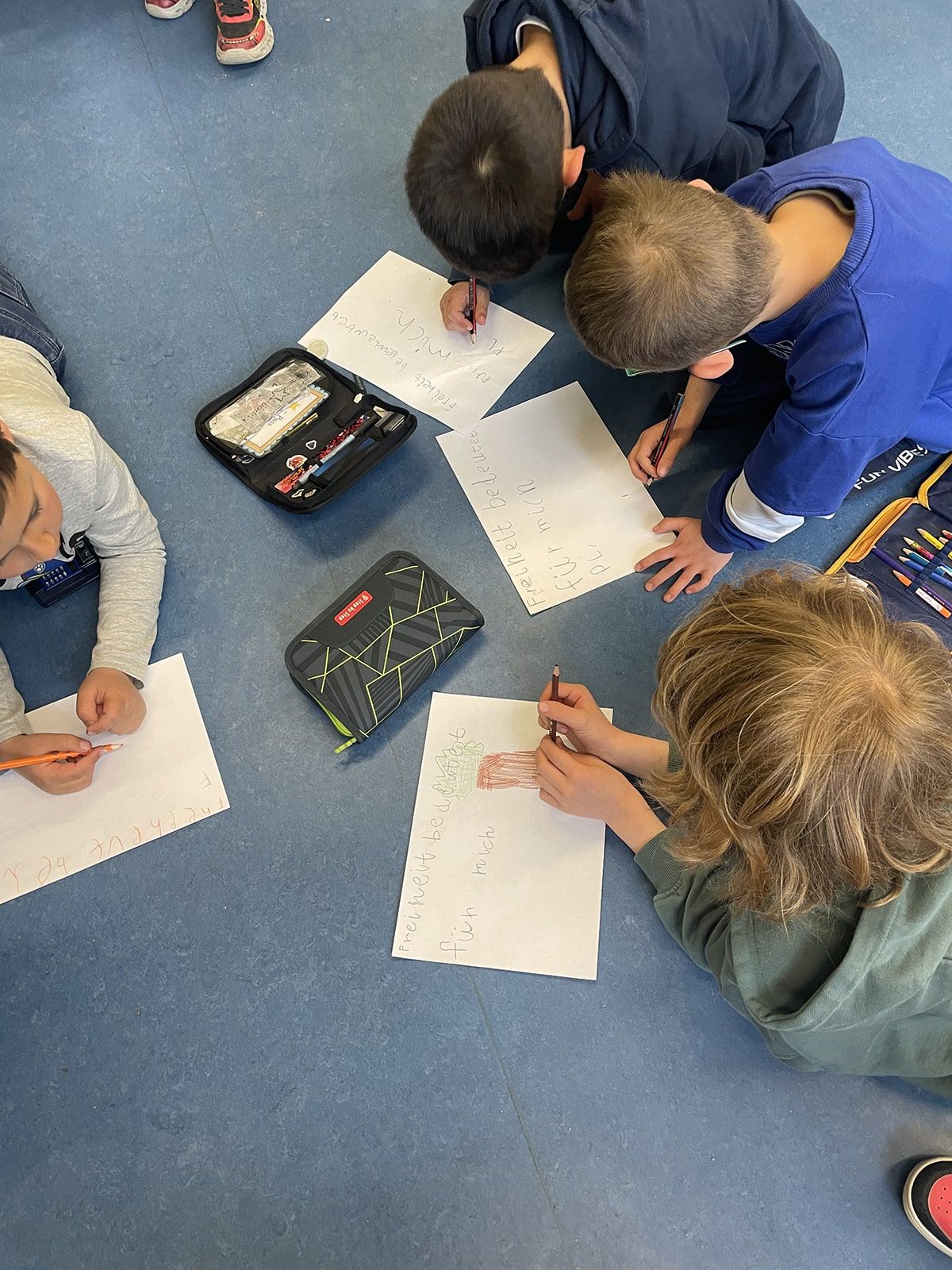 Kinder auf dem Boden notieren, was Freiheit für sie bedeutet