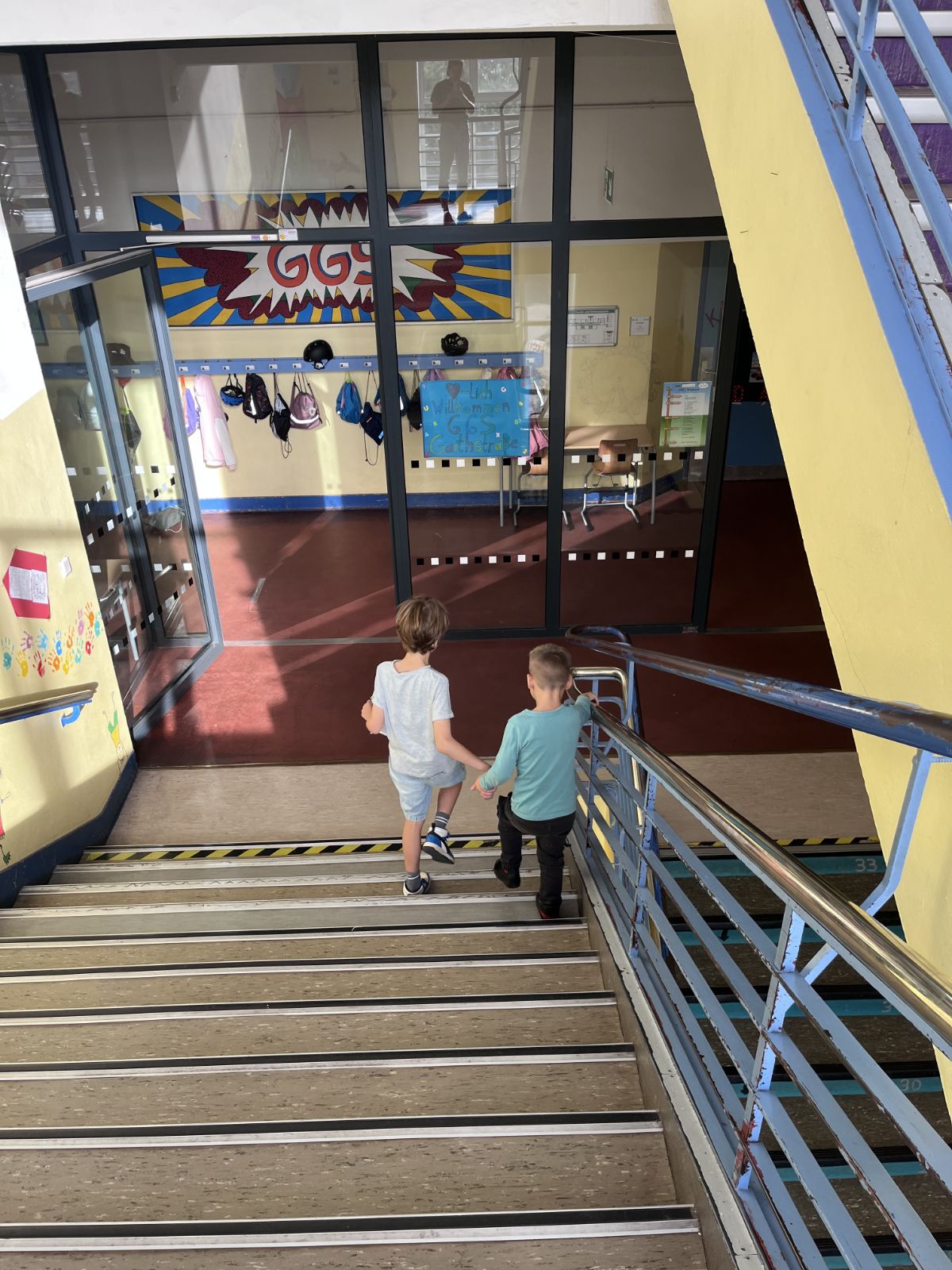 Zwei Kinder gehen zusammen eine Treppe herunter