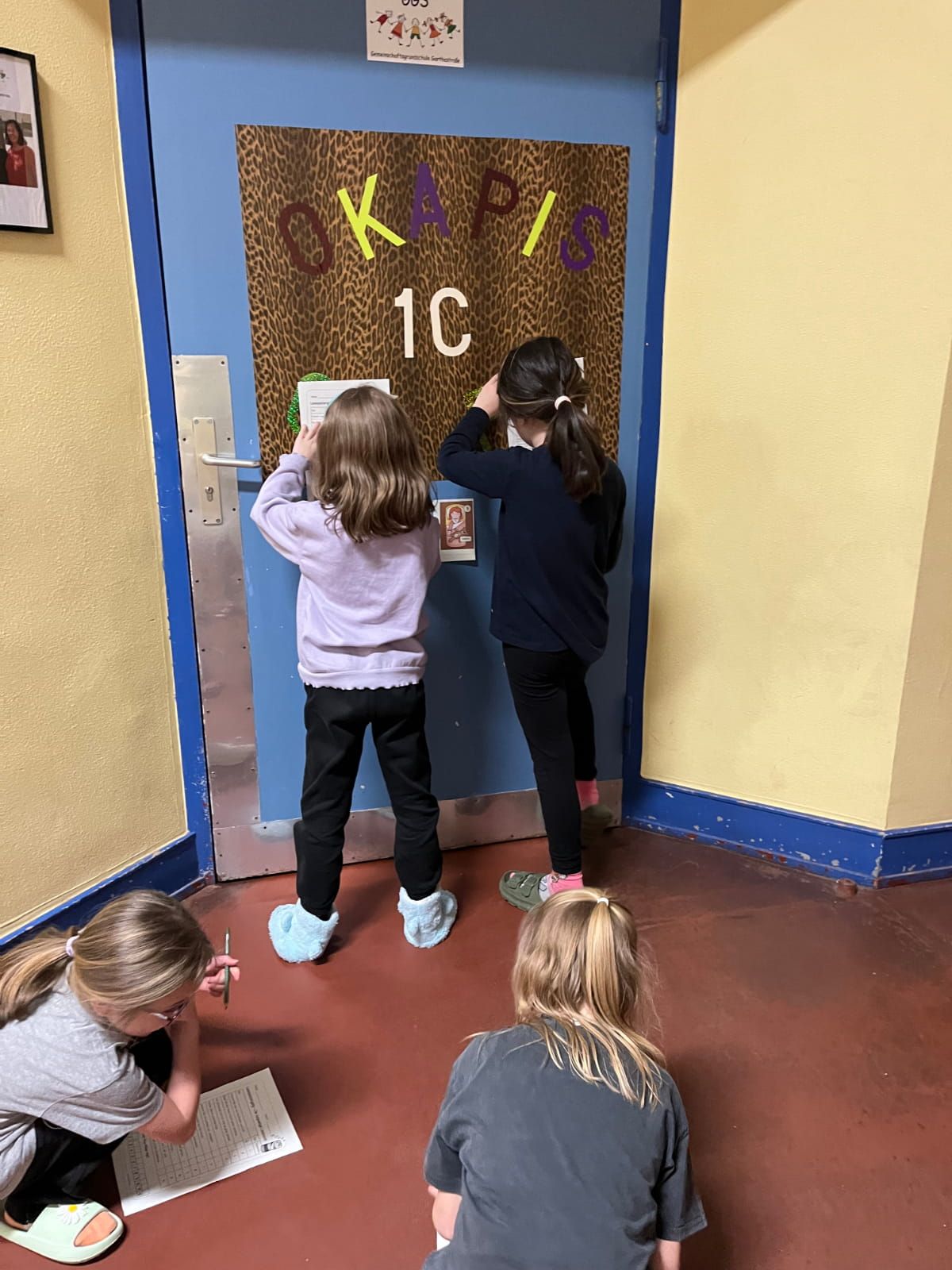 4 Kinder vor dem Klassenraum der Okapis