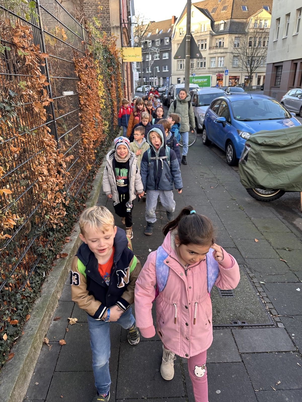 Schüler:innen laufen an einer Straße entlang