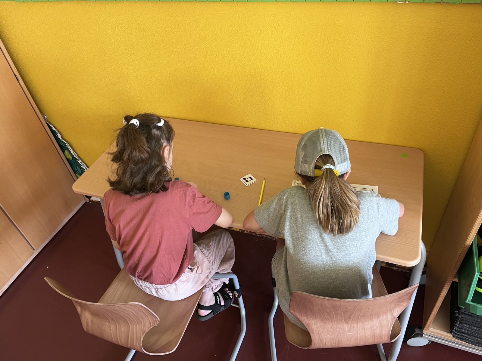 Zwei Kinder zeichnen zusammen an einem Tisch
