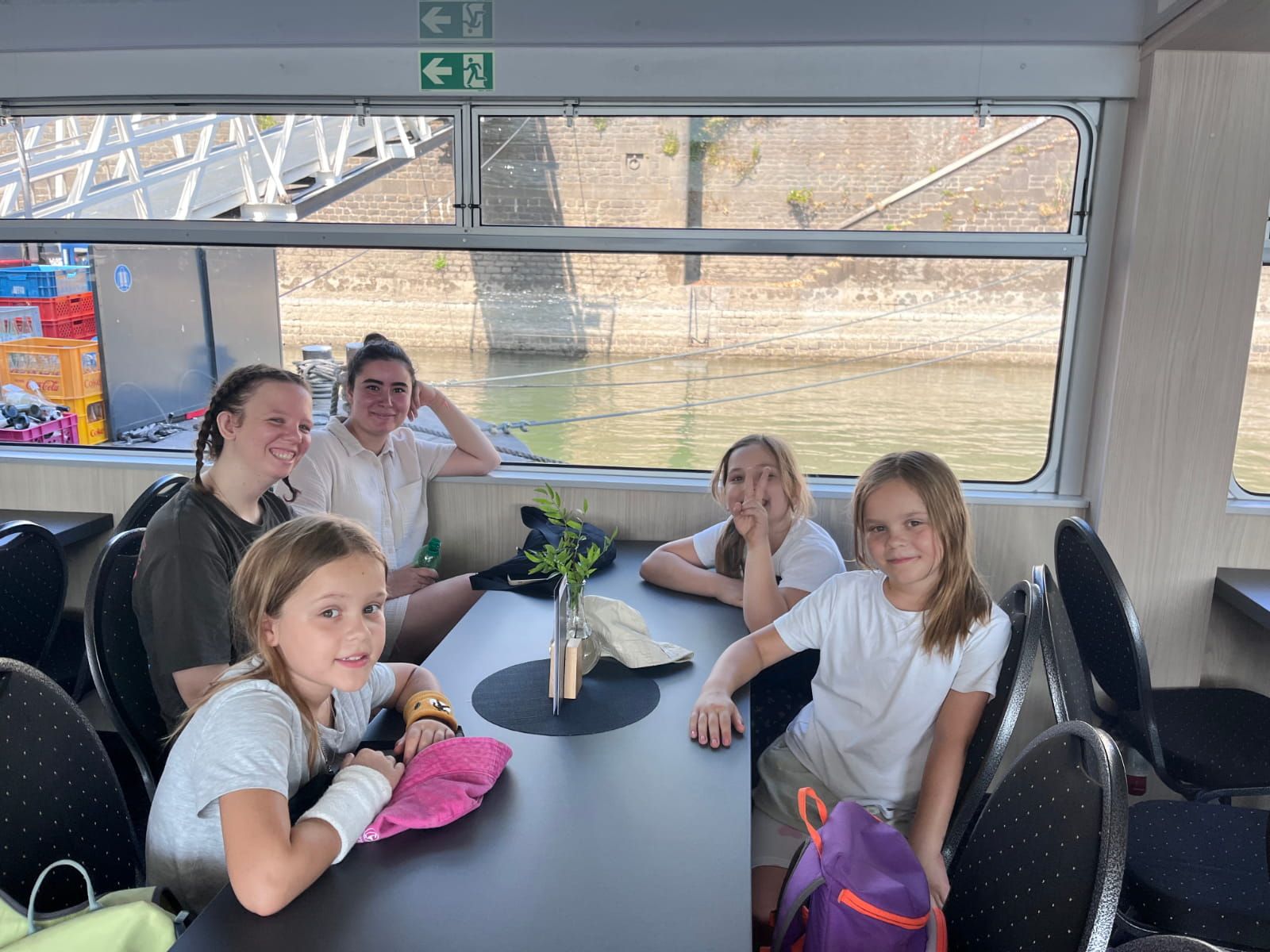 Drei Kinder und zwei Begleiterinnen sitzen in einem Boot auf dem Rhein