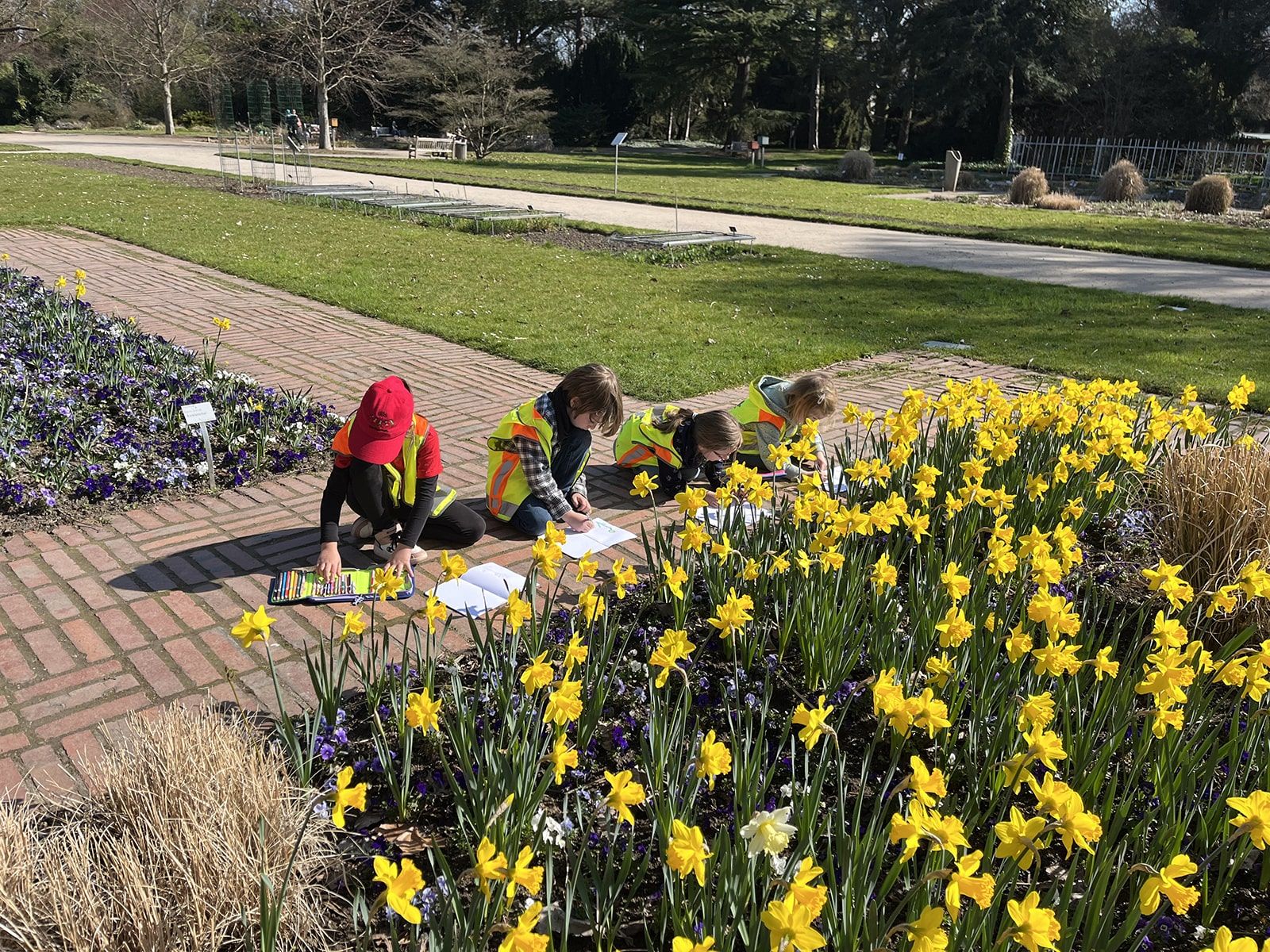 Vier Kinder zeichnen Blumen ab