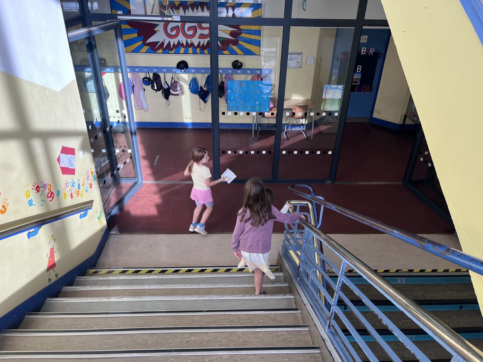Zwei Kinder gehen zusammen eine Treppe herunter