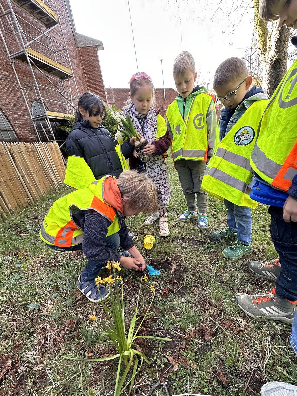 Sechs Kinder pflanzen Blumen ein
