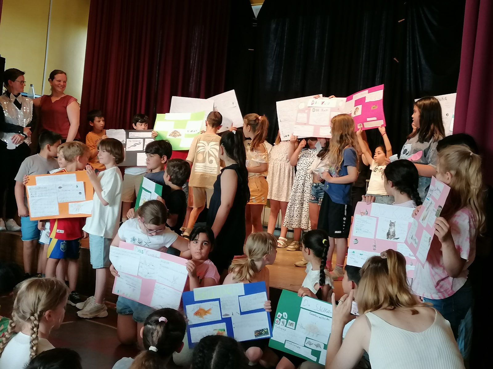 Mehrere Kinder stehen mit Plakaten auf der Bühne