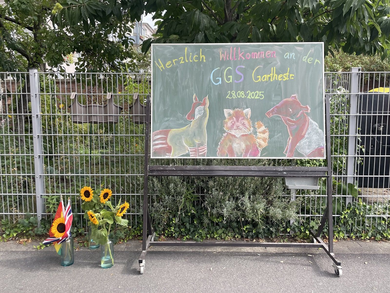 Willkommensgrüße zur Einschulung gezeichnet auf einer Tafel auf dem Schulhof