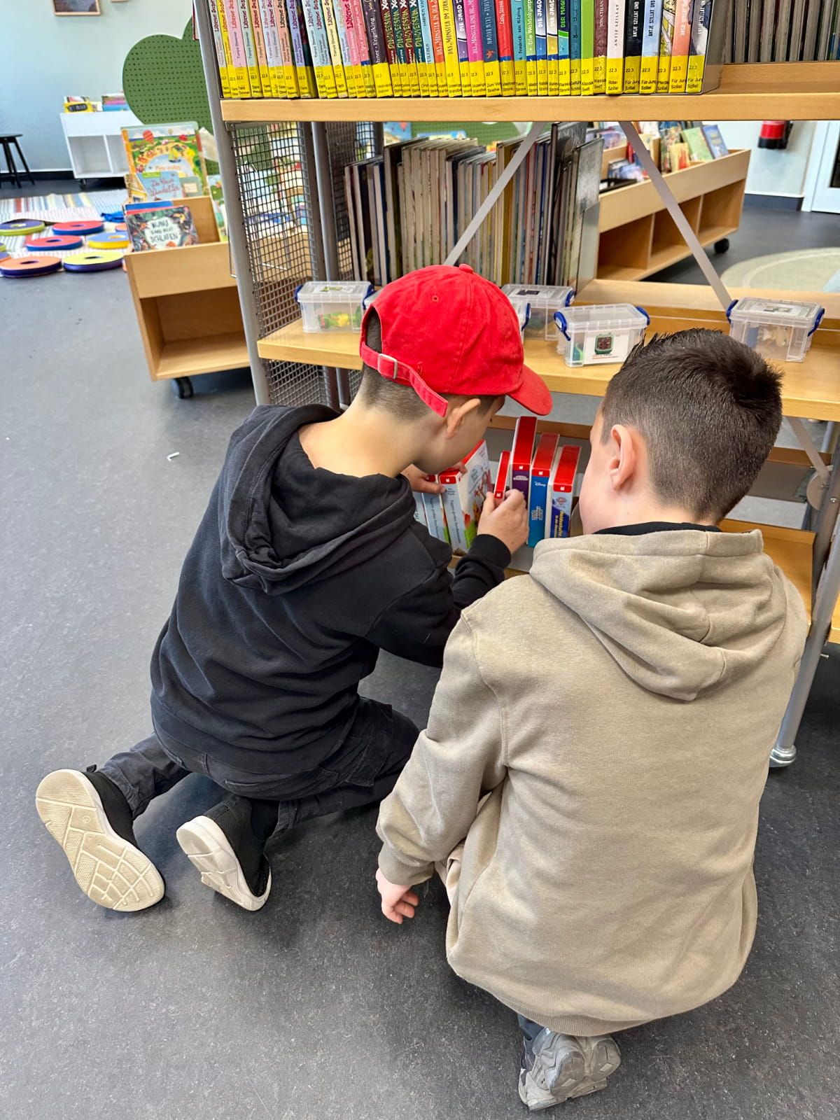 Zwei Kinder sehen sich Medien in der Bibliothek an