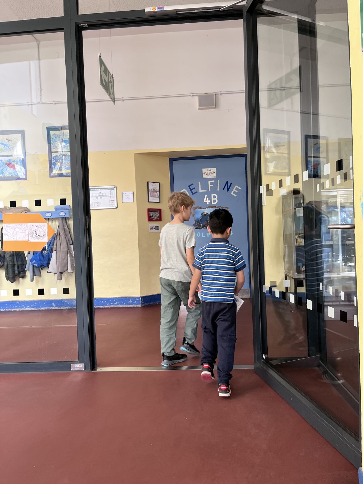 Zwei Kinder gehen zusammen durch das Schulhaus