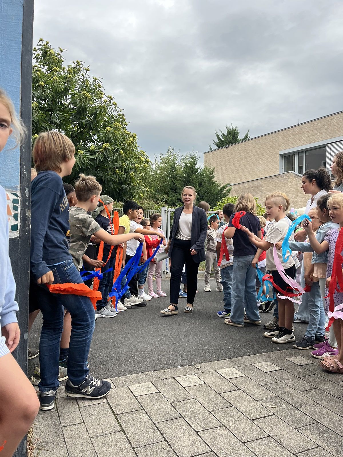 Lehrerin geht durch ein Spalier von Schulkindern