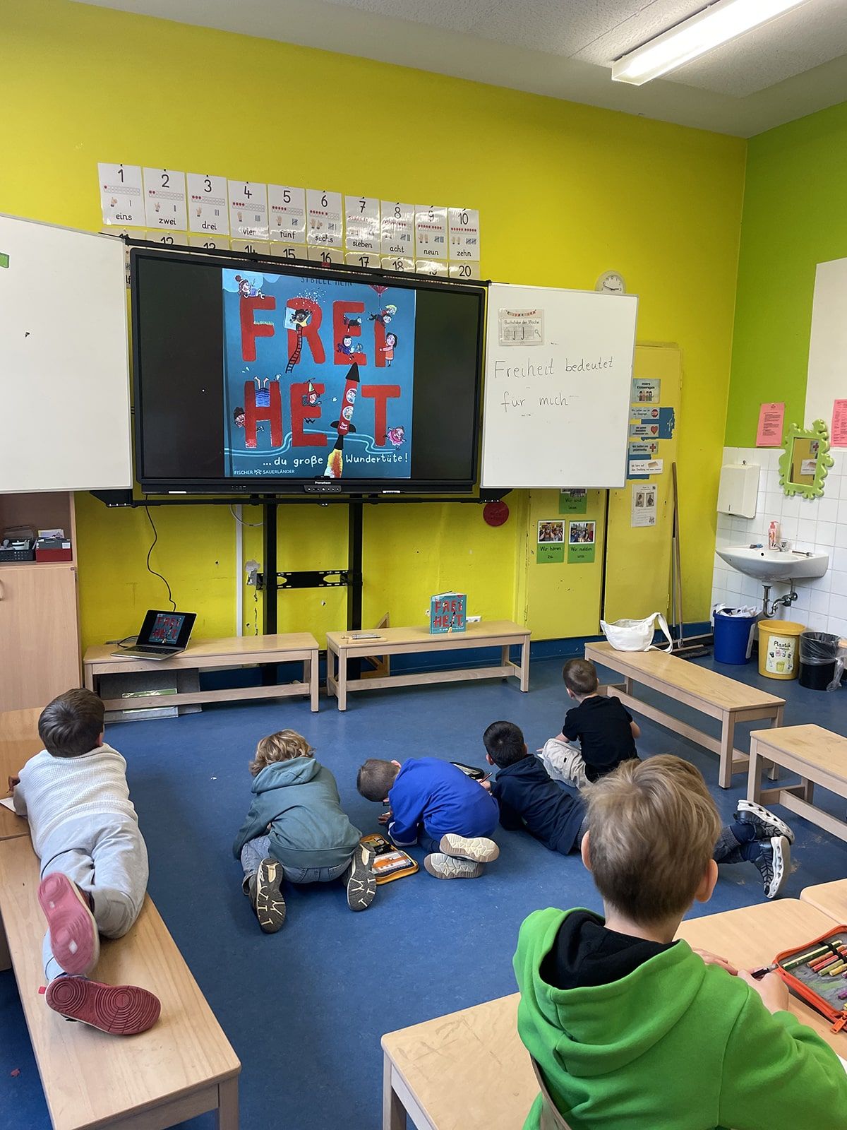 Kinder im Klassenraum notieren, was Freiheit für sie bedeutet