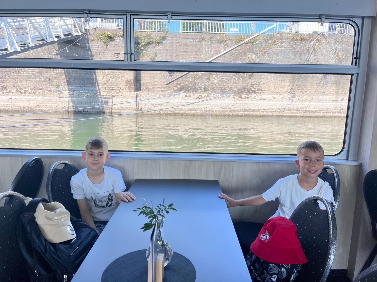 Zwei Kinder sitzen in einem Boot auf dem Rhein