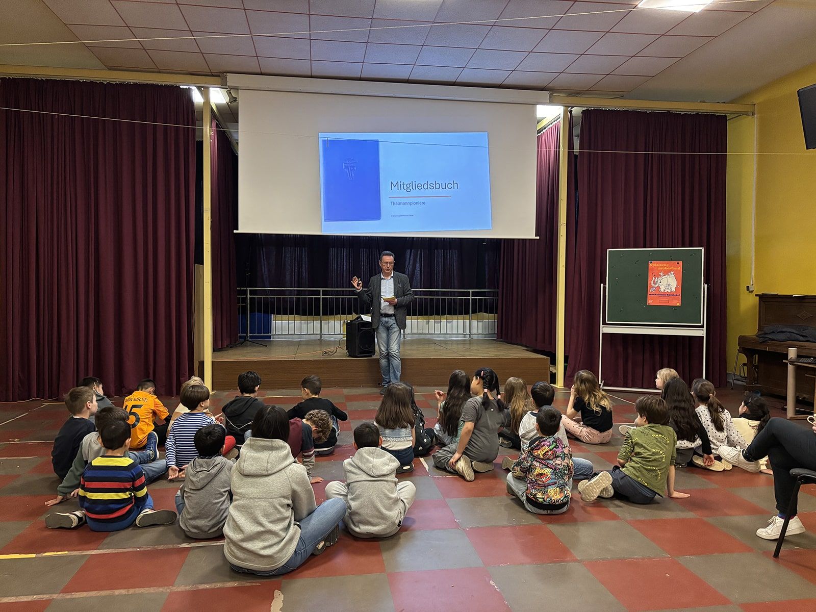 Kinder hören in der Aula einen Vortrag zum Thema DDR