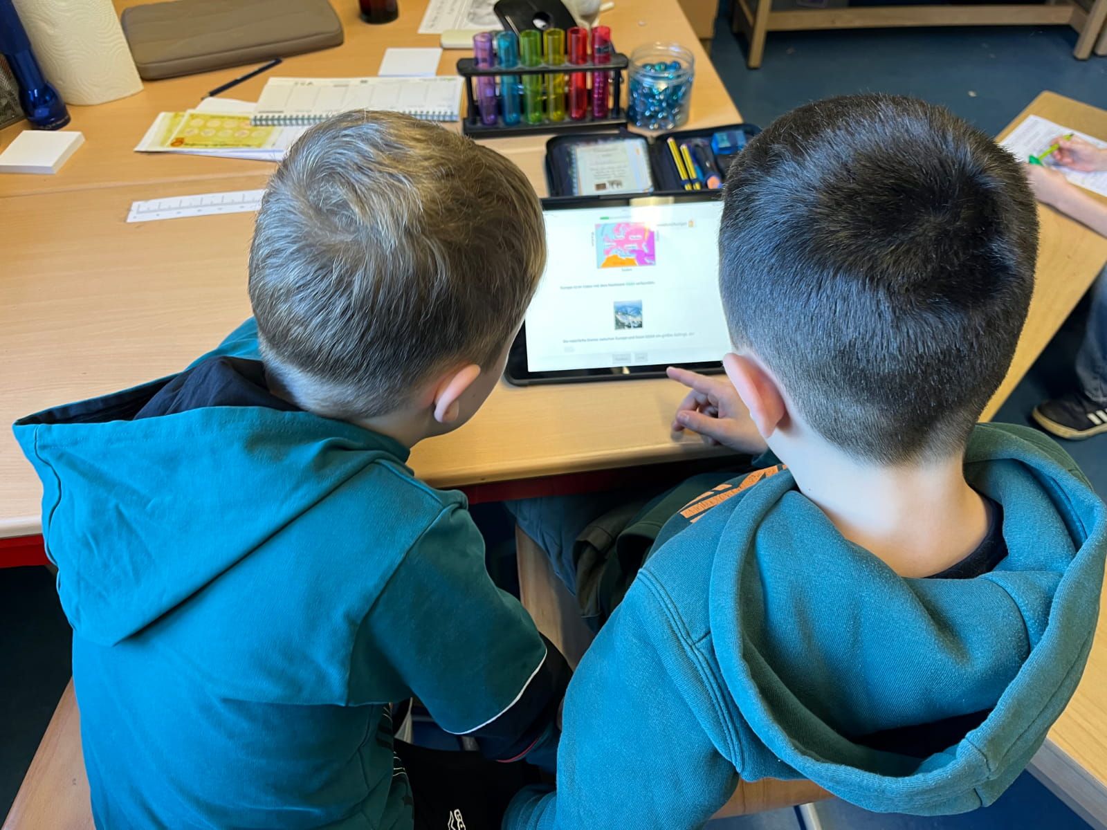 zwei Kinder sitzen vor einem Tablett