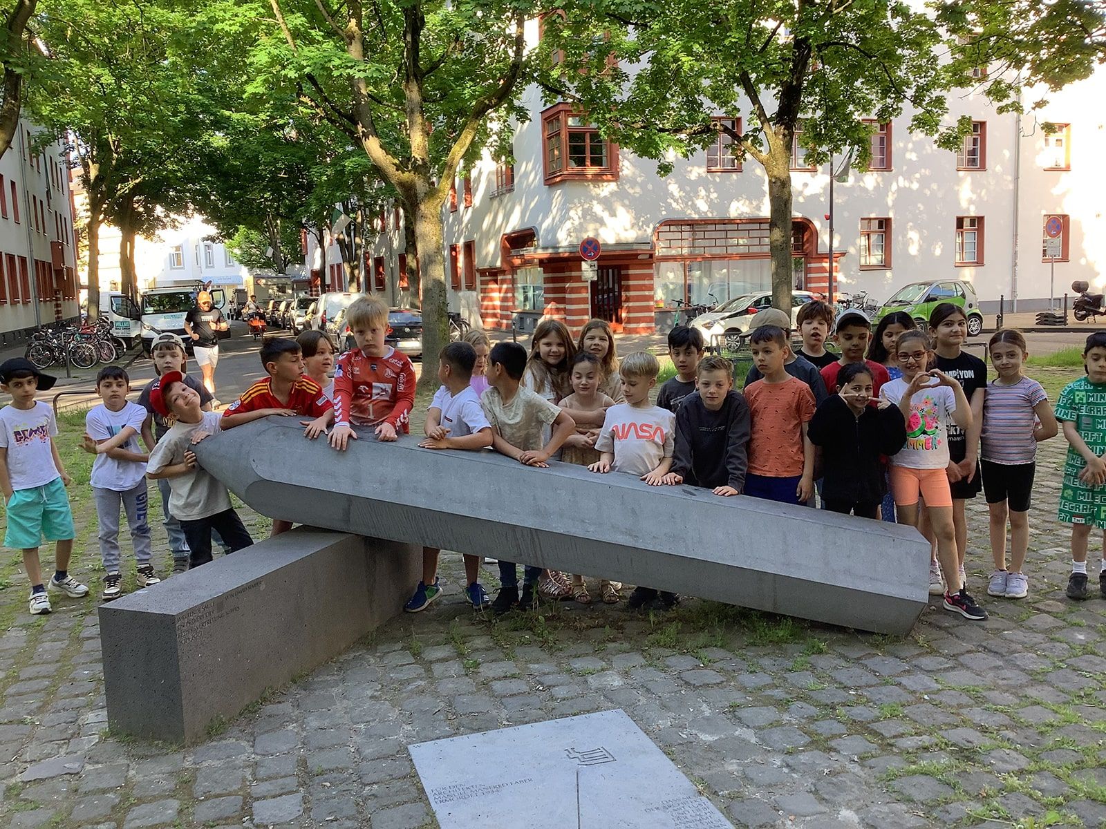 Kinder stehen hinter einer Skulptur