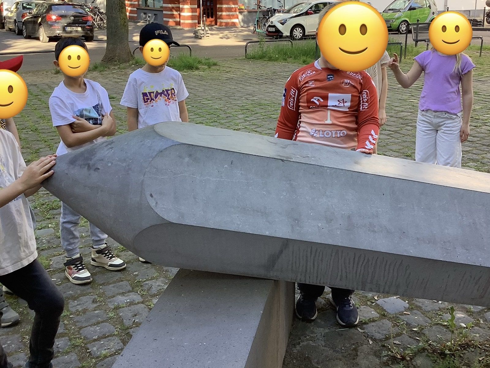 Kinder stehen neben einer Skulptur