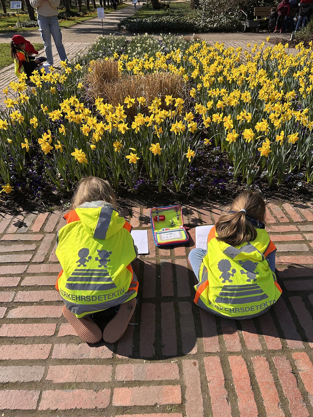 Zwei Kinder zeichnen Blumen ab